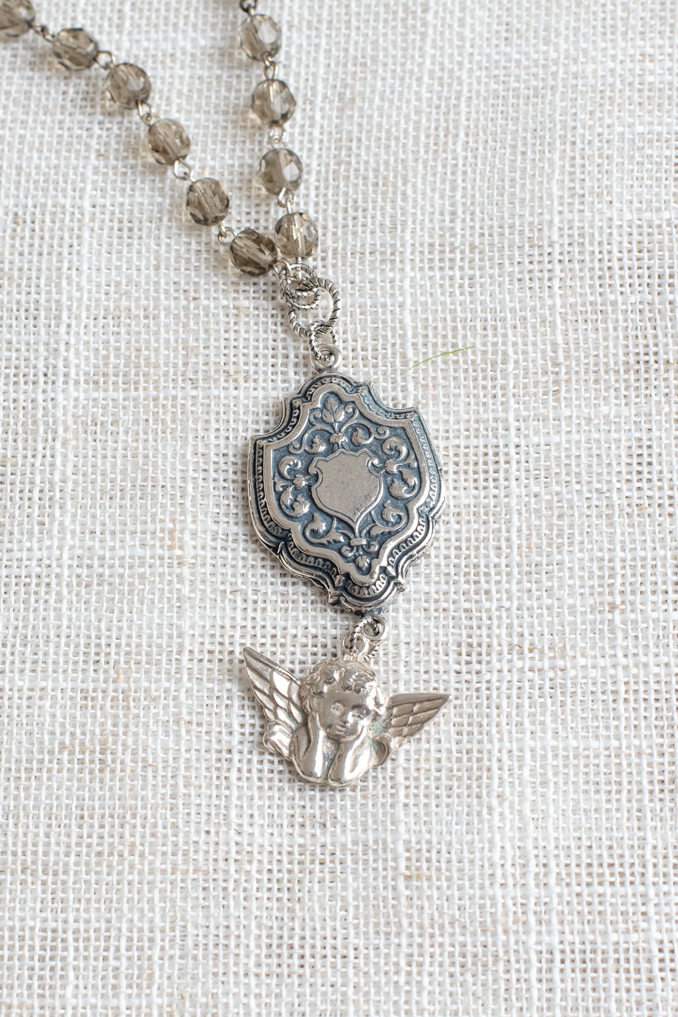 Sterling Silver Cherub and Vintage Style Silver Plated Shield Filigree Pendant on a Taupe Crystal and Silver Rosary Chain Necklace