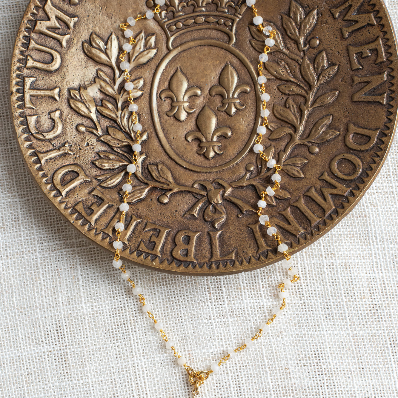 Delicate Gold Starburst Pendant on a Moonstone and Gold Plated Rosary Chain Necklace