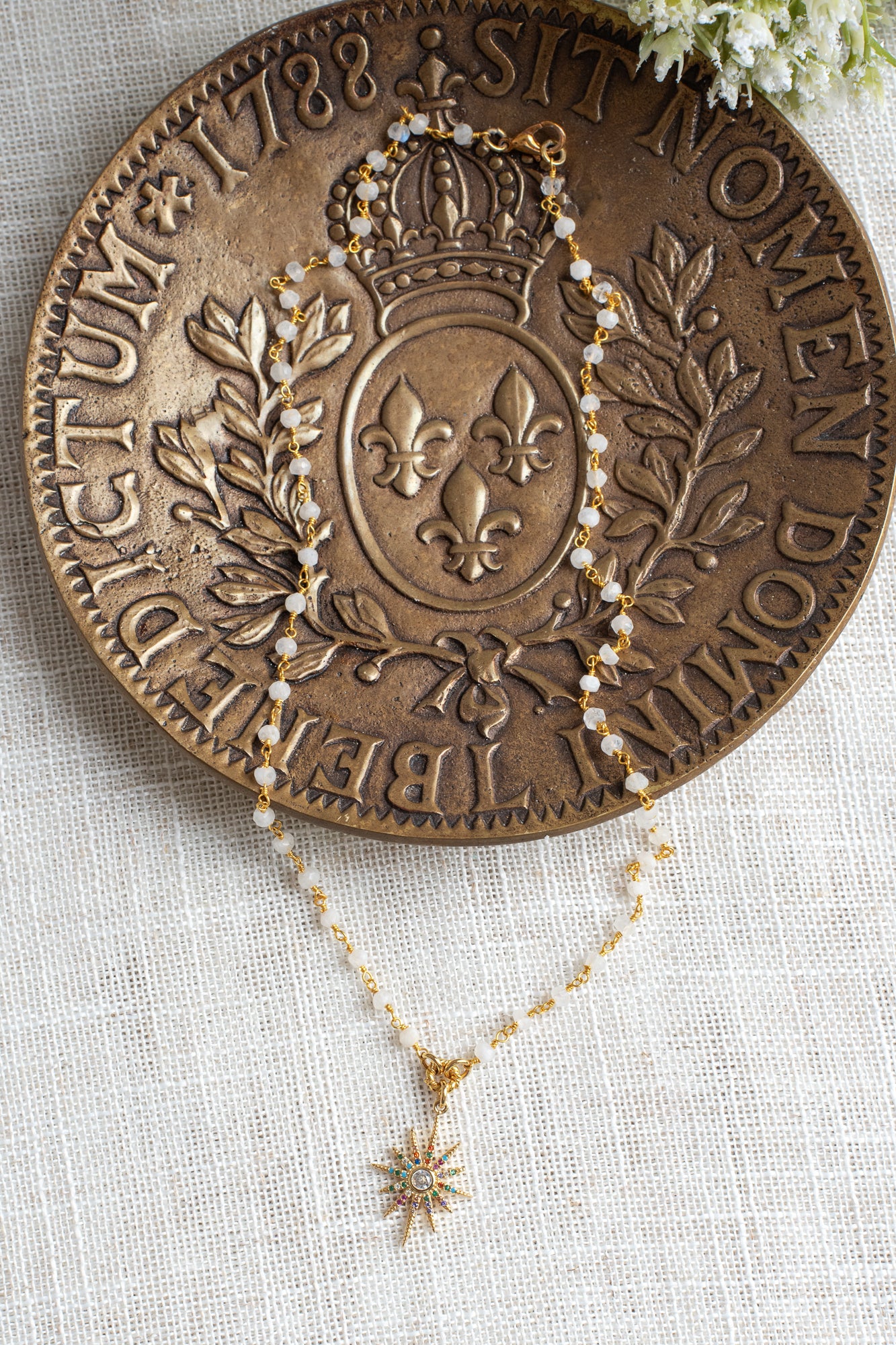 Delicate Gold Starburst Pendant on a Moonstone and Gold Plated Rosary Chain Necklace