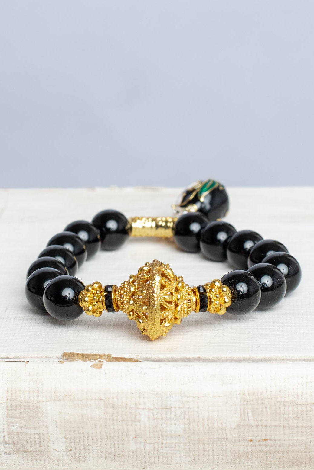 Black Onyx and Gold Bead Stretch Bracelet with Cloisonne Egg and Crystal Bow