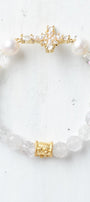 Faceted White Quartz Crystal Beaded Stretch Bracelet with a Wrist Cross Charm in Pearl and Crystal with Gold Plating.
