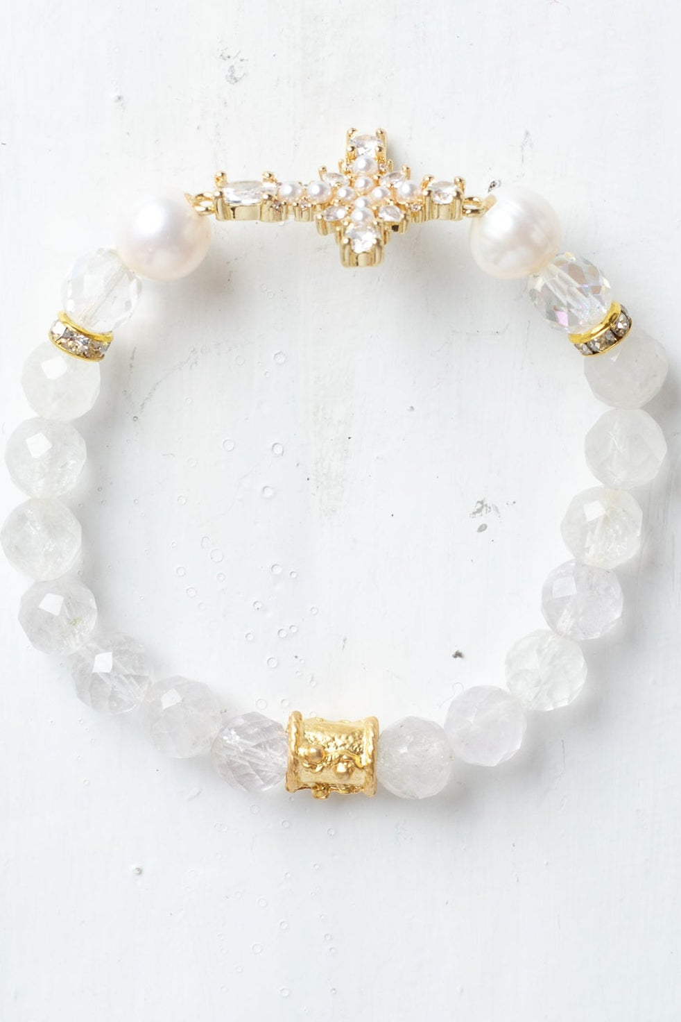 Faceted White Quartz Crystal Beaded Stretch Bracelet with a Wrist Cross Charm in Pearl and Crystal with Gold Plating.