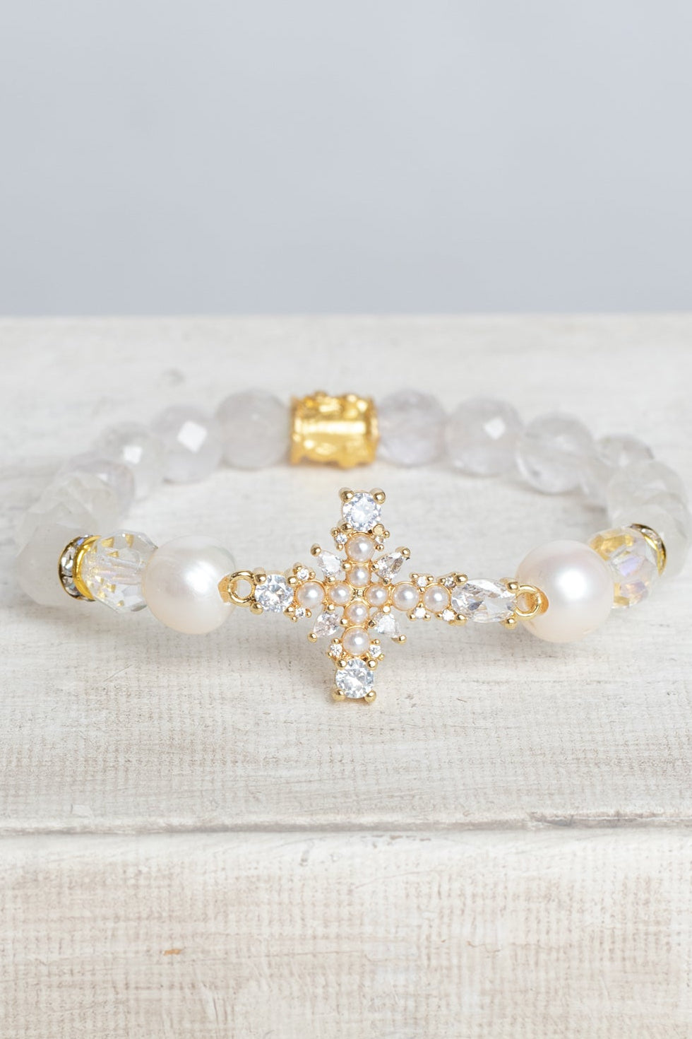 Faceted White Quartz Crystal Beaded Stretch Bracelet with a Wrist Cross Charm in Pearl and Crystal with Gold Plating.