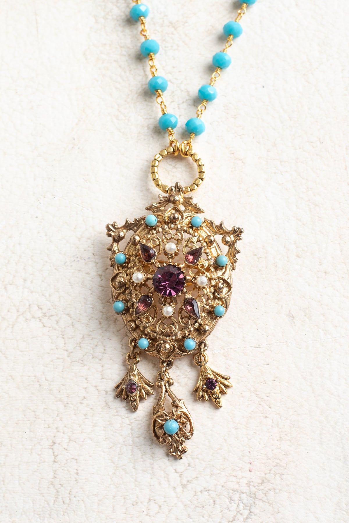 Vintage Gold Designer Brooch Pendant with Purple Rhinestones, Turquoise and Pearl Accents on a Turquoise and Gold Rosary Chain Necklace