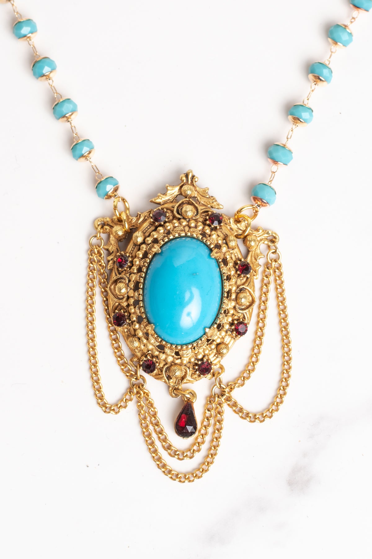 Vintage Gold Plated Florenza Collectible Pendant with Red Rhinestones, Faux Turquoise Cabachon and Chain Draping on a Turquoise and Gold Rosary Chain Necklace