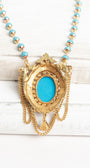 Vintage Gold Plated Florenza Collectible Pendant with Red Rhinestones, Faux Turquoise Cabachon and Chain Draping on a Turquoise and Gold Rosary Chain Necklace