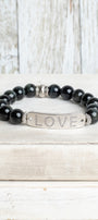 Silver Center Plate with LOVE in Crytal Letters on Black Obsidian Beads with Hints of Gray Stretch Bracelet