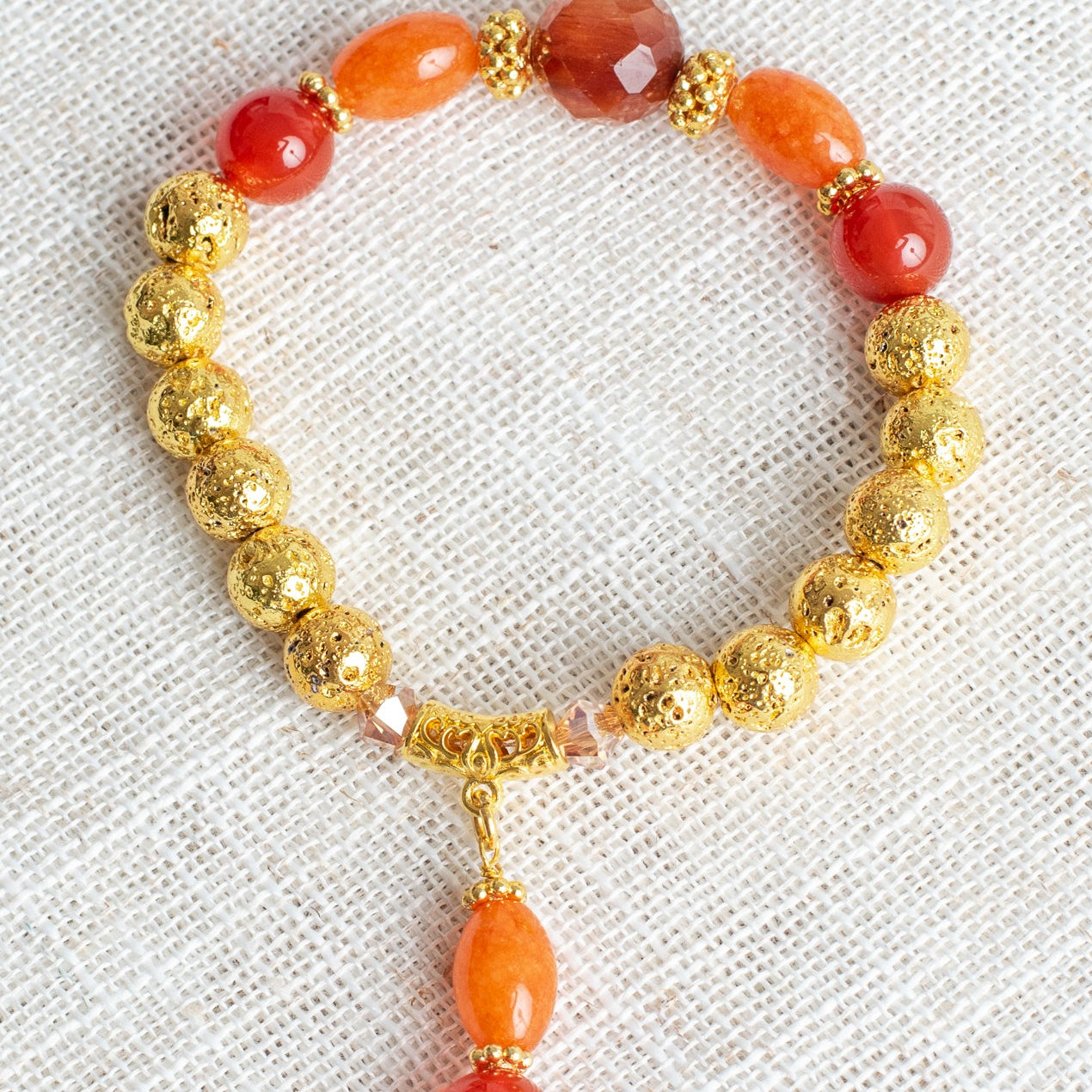 Carnelian and Orange Quartz Stone Beads with 14K Gold Plated Lava Stone Beads on a Stretch Bracelet with Beaded Charm