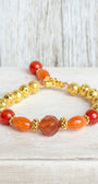 Carnelian and Orange Quartz Stone Beads with 14K Gold Plated Lava Stone Beads on a Stretch Bracelet with Beaded Charm